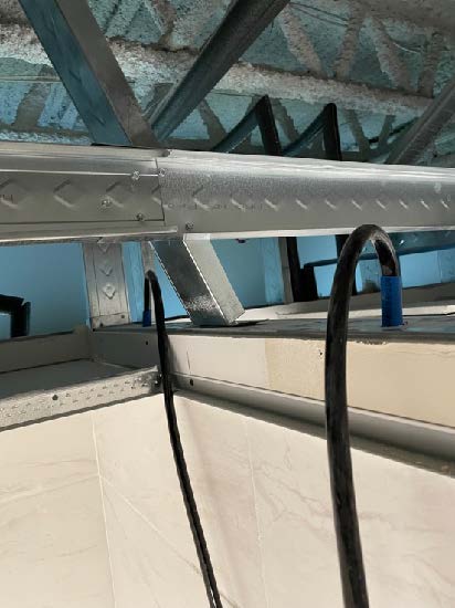 Ducting air behind walls through a suspended ceiling to assist in water mitigation